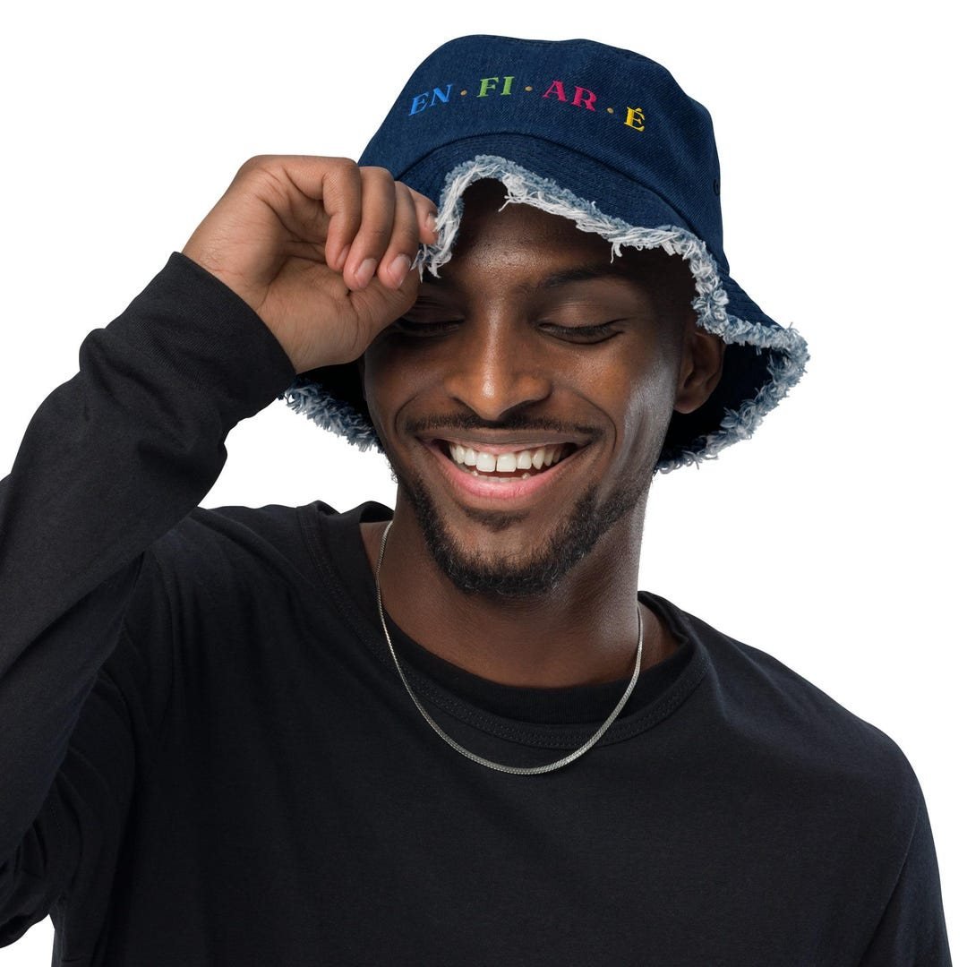 Navy distressed denim bucket hat with EN, FI, AR and É lettered in color across the crown.
