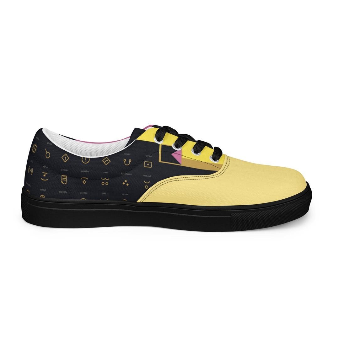 Low-top canvas sneakers with the É mark across the upper in yellow, black and pink.